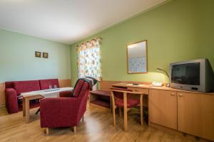a room with a desk and a tv and chairs at Penzion Eso in Martin