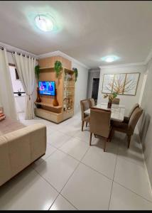 a living room with a couch and a table at Apto amplo e confortável in Aracaju