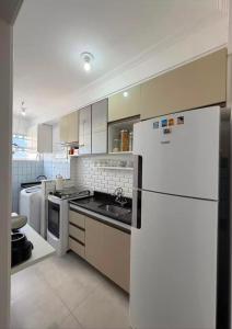 a kitchen with white appliances and a white refrigerator at Apto amplo e confortável in Aracaju