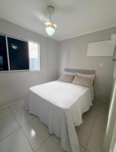 a white bedroom with a bed with a white bedspread at Apto amplo e confortável in Aracaju +8 photos