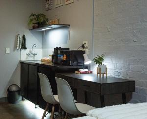 a desk with two chairs and a computer on it at The Hideaway Studio-Maboneng in Johannesburg