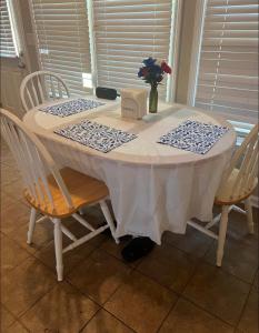 a white table with chairs and a vase of flowers on it at Stone Homes in Lawrenceville