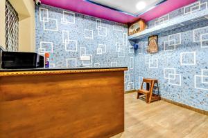 a bar in a room with a wall covered in tiles at OYO 80514 Moody Moon in Bārang