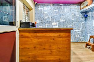 a kitchen with a wooden counter top and a wall at OYO 80514 Moody Moon in Bārang