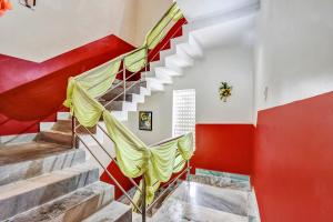 a staircase with red and white walls at OYO 80514 Moody Moon in Bārang +21 photos