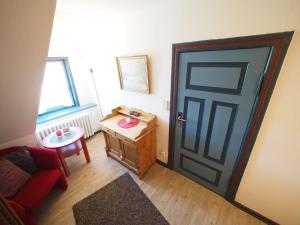 a room with a door and a red couch and a table at Hansen-Hof-Wohnung-2 in Tinnum +8 photos