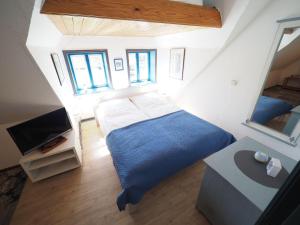 a bedroom with a blue bed and a television at Hansen-Hof-Wohnung-2 in Tinnum