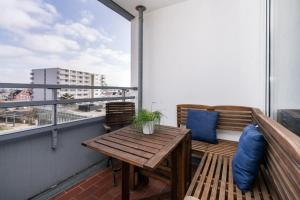 a balcony with a wooden table and two chairs at Ferienwohnung-Hansen in Westerland