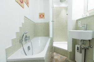 a bathroom with a bath tub and a sink at Ferienwohnung-Hansen in Westerland