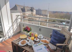 a table with food and drinks on a balcony at Ferienwohnung-Hansen in Westerland +6 photos