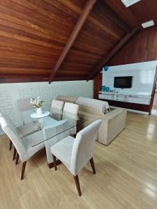 a living room with a couch and a table and chairs at Deruci Chale in Nova Friburgo