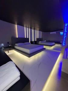 a bedroom with two beds in a room with lights at Khalifa Experience Motel in Itumbiara