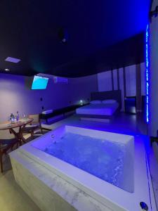 a large bath tub in a room with a table at Khalifa Experience Motel in Itumbiara