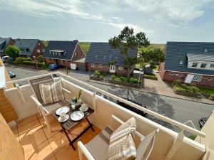 a balcony with a table and chairs and a view of a street at Appartement-152 in Westerland
