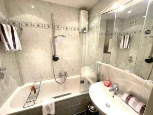 a bathroom with a tub and a sink and a shower at Appartement-152 in Westerland
