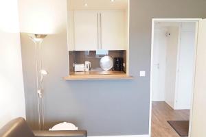 a kitchen with white cabinets and a lamp at Appartement-155 in Westerland