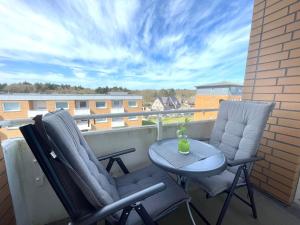 a balcony with two chairs and a table with a vase on it at Appartement-155 in Westerland