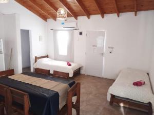 a room with two beds and a chair in it at Posada del Guardián in Villa Yacanto +6 photos