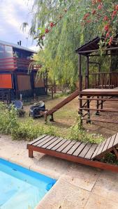 a playground with a wooden bench next to a pool at Posada del Guardián in Villa Yacanto