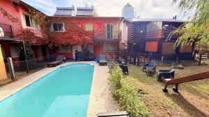 a house with a swimming pool in front of a house at Posada del Guardián in Villa Yacanto