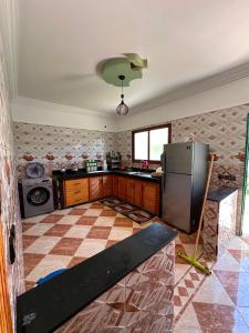 a kitchen with a refrigerator and a tile floor at Villa Basmat in Oualidia