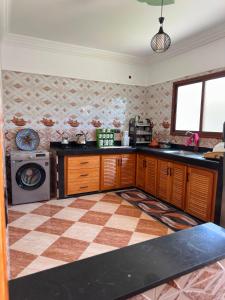 a kitchen with a checkered floor and a washer at Villa Basmat in Oualidia