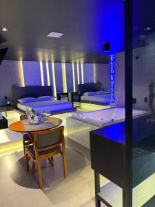 a room with a table and a room with beds at Khalifa Experience Motel in Itumbiara +4 photos
