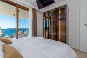 a bedroom with a large white bed and a balcony at Royal Oak beachfront residence Trogir Seget Vranjica in Seget Vranjica +100 photos