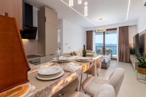 a kitchen and living room with a table and chairs at Royal Oak beachfront residence Trogir Seget Vranjica in Seget Vranjica