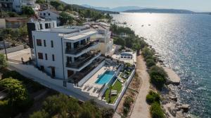 an aerial view of a large white house next to the water at Royal Oak beachfront residence Trogir Seget Vranjica in Seget Vranjica