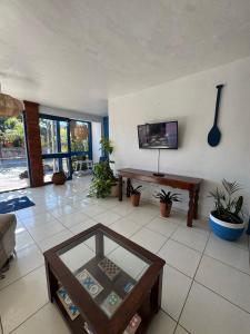 a living room with a table and a tv at Luah Buziana in Búzios