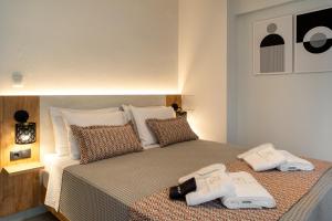 a bedroom with a bed with two towels on it at AKSQUARED Premium Vacation Apartments in Paralia Dionysiou