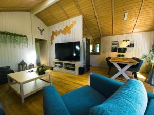 a living room with a blue couch and a tv at Ferienhaus-Bambi in Haren