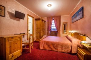 una camera con letto, scrivania e finestra di Hotel Des Glaciers a Courmayeur