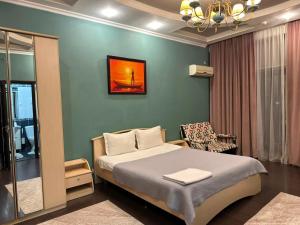 a bedroom with a bed and a chair in it at Dostyq in Astana