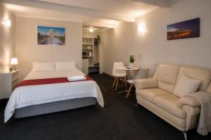 a bedroom with a bed and a couch and a table at The Cave Motel in Levin