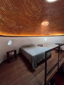 a bedroom with a bed and a wooden floor at La cabaña del jaguar in Tepoztlán