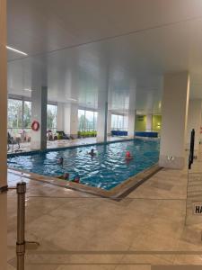 a large swimming pool with people in the water at Novaterra Cerezo in Mosquera