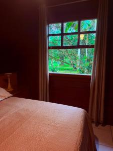 a bedroom with a bed and a window at Casa do Zeca Morretes in Morretes +33 photos