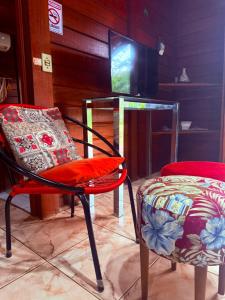 a room with two chairs and a television at Casa do Zeca Morretes in Morretes