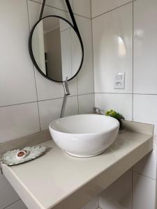a bathroom with a white sink and a mirror at Apt Serras Gerais Superior in Dianópolis