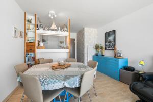 a dining room with a table and a blue cabinet at Lombardie 0502 in Nieuwpoort +8 photos