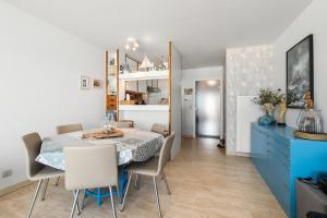 a dining room with a table and chairs and a blue dresser at Lombardie 0502 in Nieuwpoort
