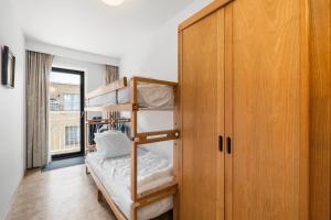 a bedroom with a bunk bed and a wooden cabinet at Lombardie 0502 in Nieuwpoort