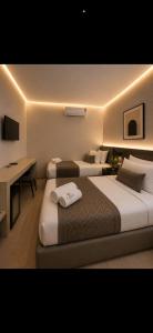a hotel room with two beds and a desk at tyty cairo hotel in Cairo