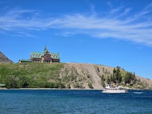 a boat in the water in front of a castle at Red Coat Inn Motel in Fort Macleod