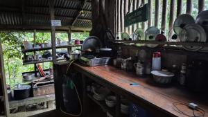 a kitchen with a counter with plates and pans at Huaca Huaca Hostel in Mocoa +117 photos