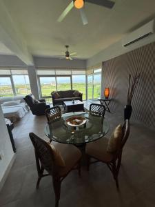 a living room with a glass table and chairs at departamento 314 in Nuevo Nayarit +4 photos