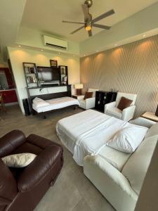 a bedroom with a bed and a couch and a tv at departamento 314 in Nuevo Nayarit