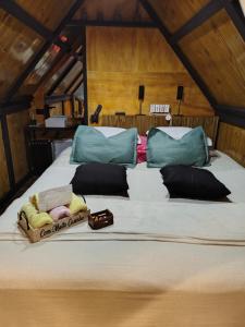 a large bed with pillows and towels on it at Cabana recanto da TOCA in Ilhabela